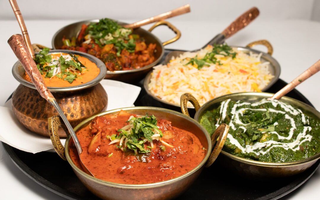 Curries served in copper bowls with rice